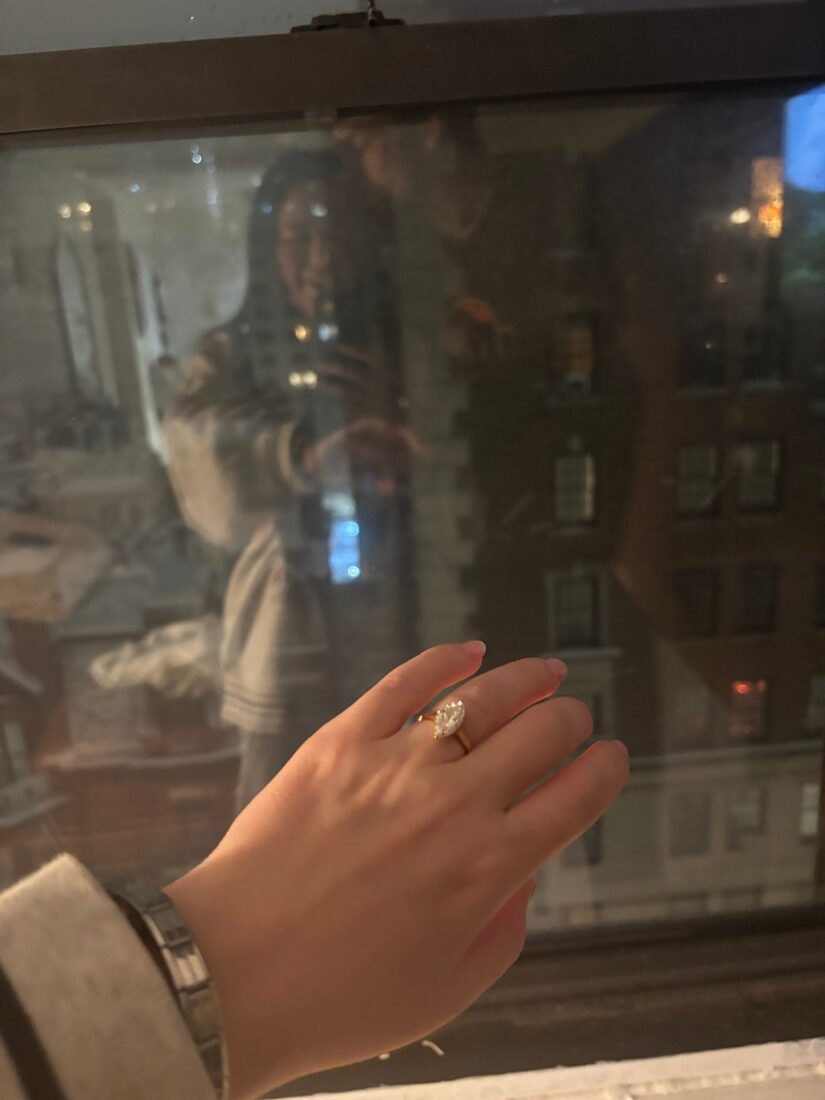Engagement ring shown against a city window at night
